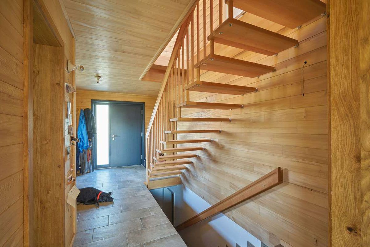Flur aus Massivholz mit Treppe ins Ober- und Untergeschoss