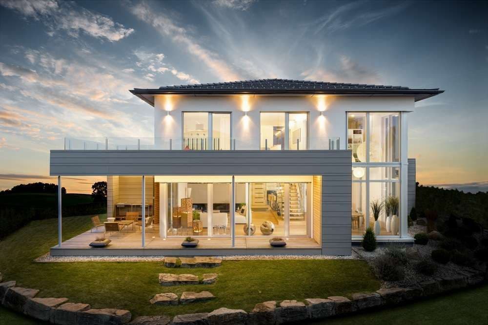 Moderne Stadtvilla mit Erker, Dachterrasse und Abendbeleuchtung