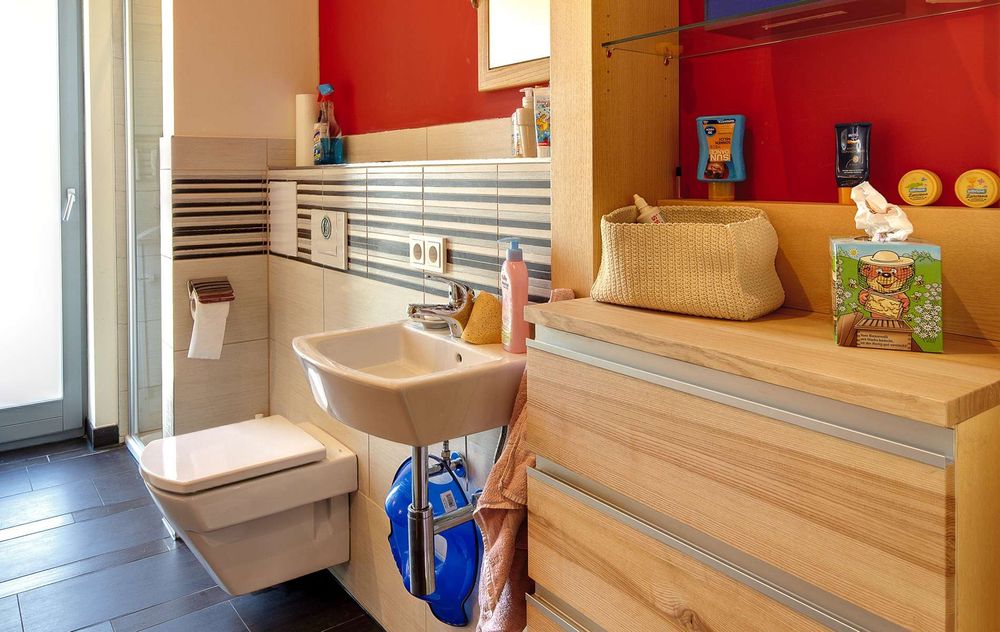 Kinderbadezimmer mit WC, Waschbecken und Holzkommode