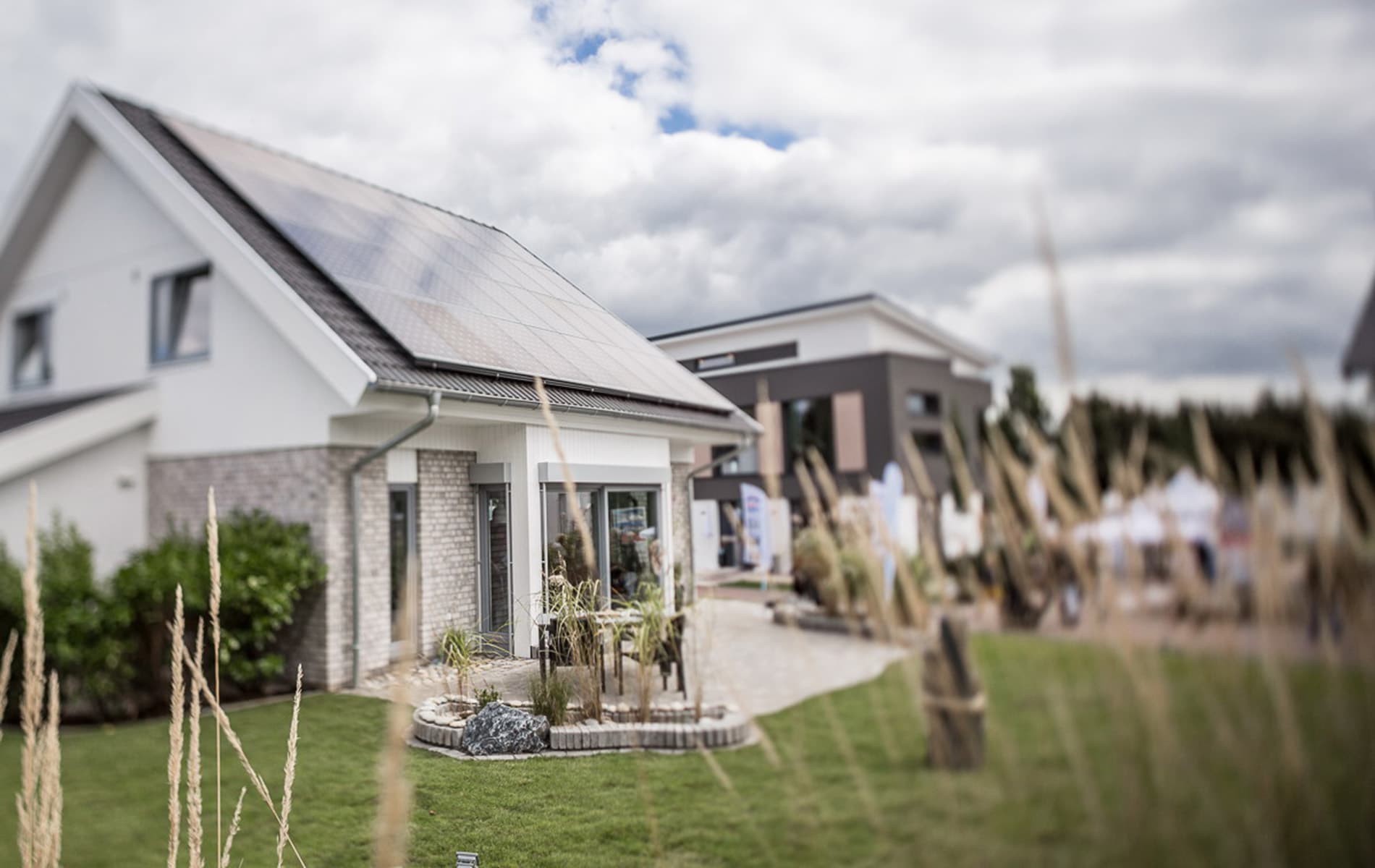Modernes Einfamilienhaus mit Garten, Terrasse und Solarpanels auf dem Dach