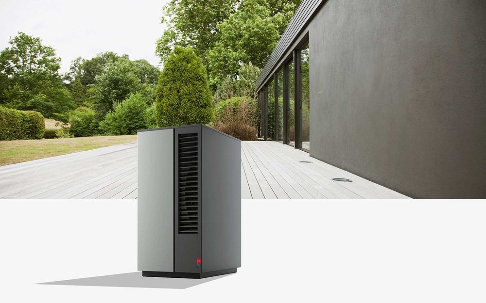 Graue Glen-Dimplex Wärmepumpe mit Garten im Hintergrund