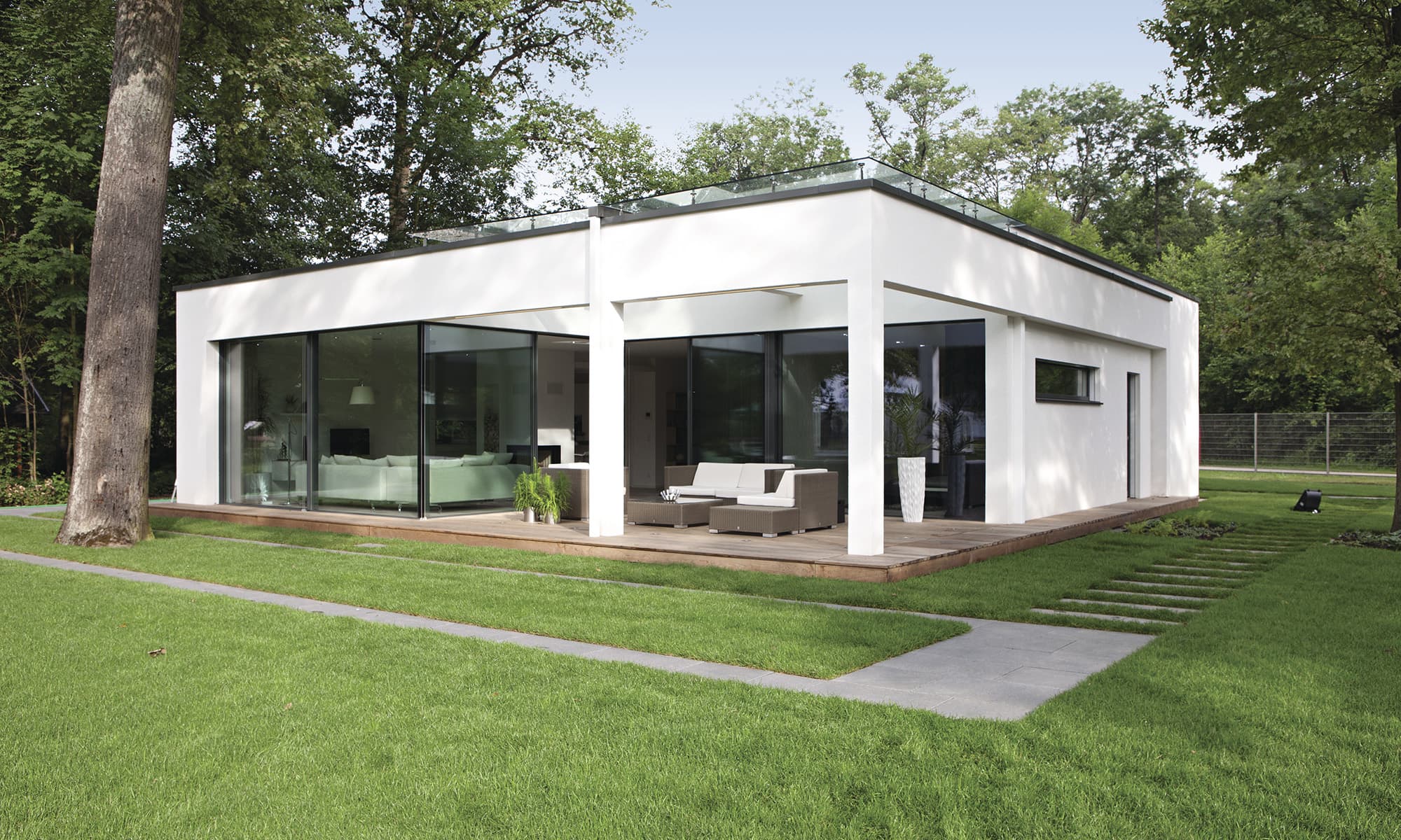 Kleines Fertighaus mit Putzfassade, Flachdach und überdachter Terrasse