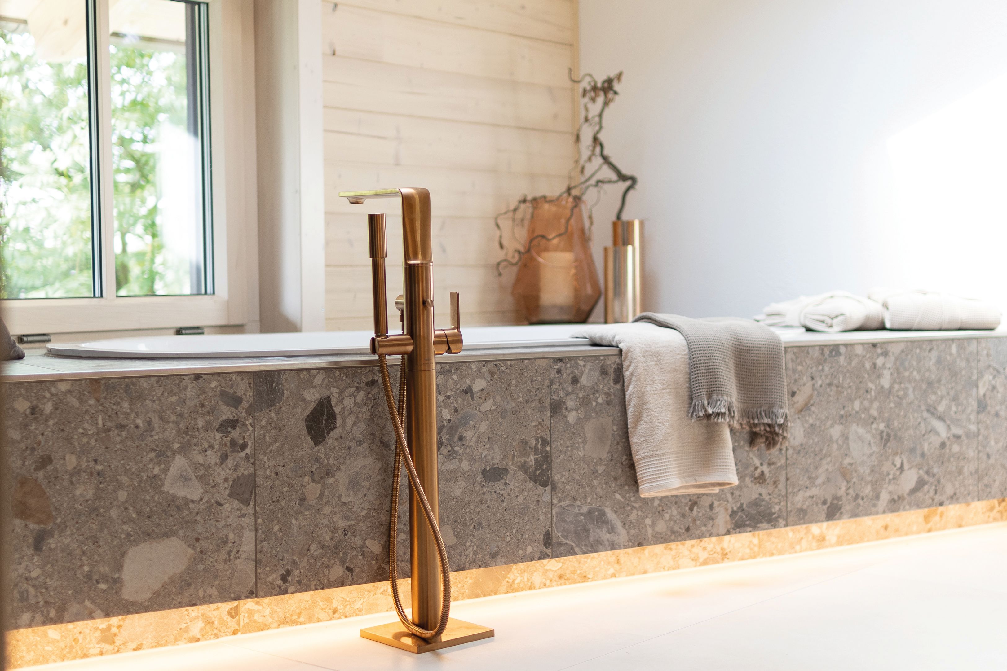 Die messingfarbenen Armaturen im oberen Bad des modernen und großzügigen Holzhauses, bzw. Massivholzhauses im Landhausstil im Musterhauspark in Ortenburg. Der Neubau erinnert an die Chalets im Alpenvorland, hat aber viele moderne Designelemente.