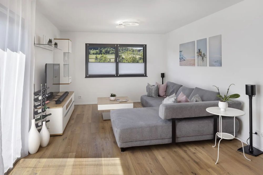 Heller Wohnbereich mit Ecksofa und Holzparkett