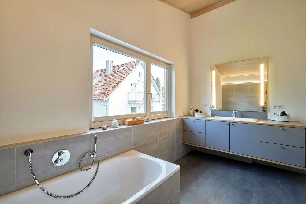 Badezimmer mit dunklen Badezimmer-Fliesen und heller Putzwand